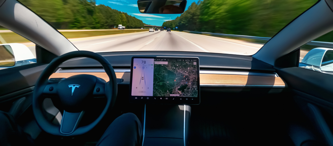Tesla touch screen as illustration for "playing while driving" feature