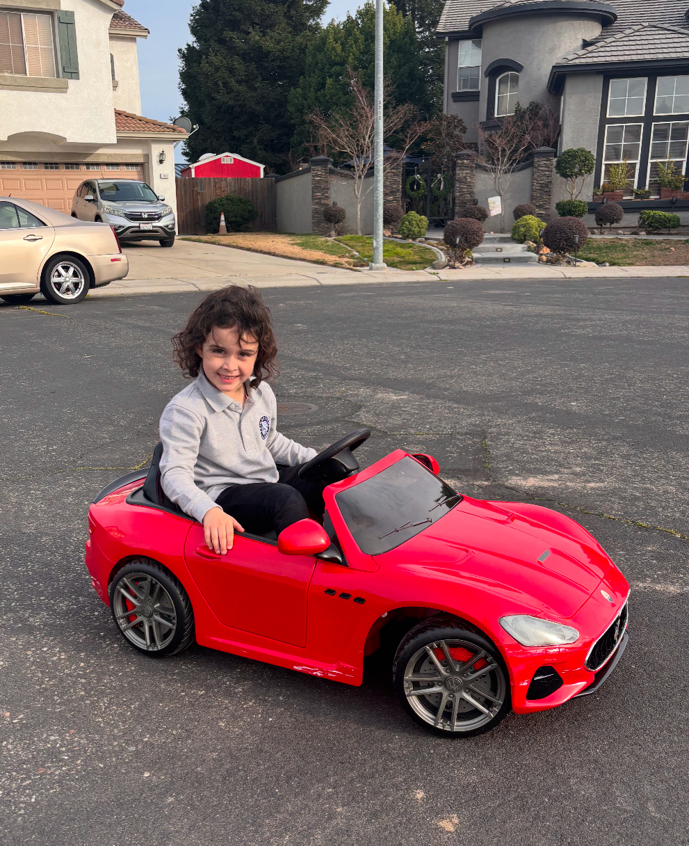 Aria Boyan rides her mini car, won in the Kars4Kids 30th anniversary Cars for Kids celebration giveaway, side view